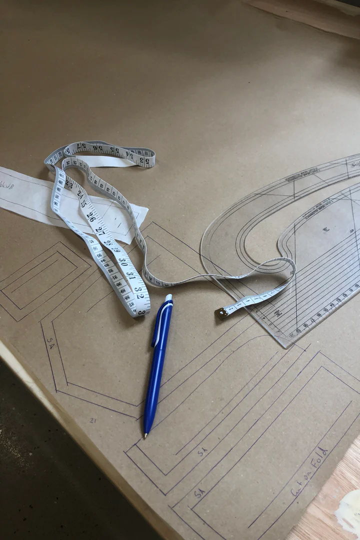 Table has pen tape measure and clothing pattern for jean leg alterations